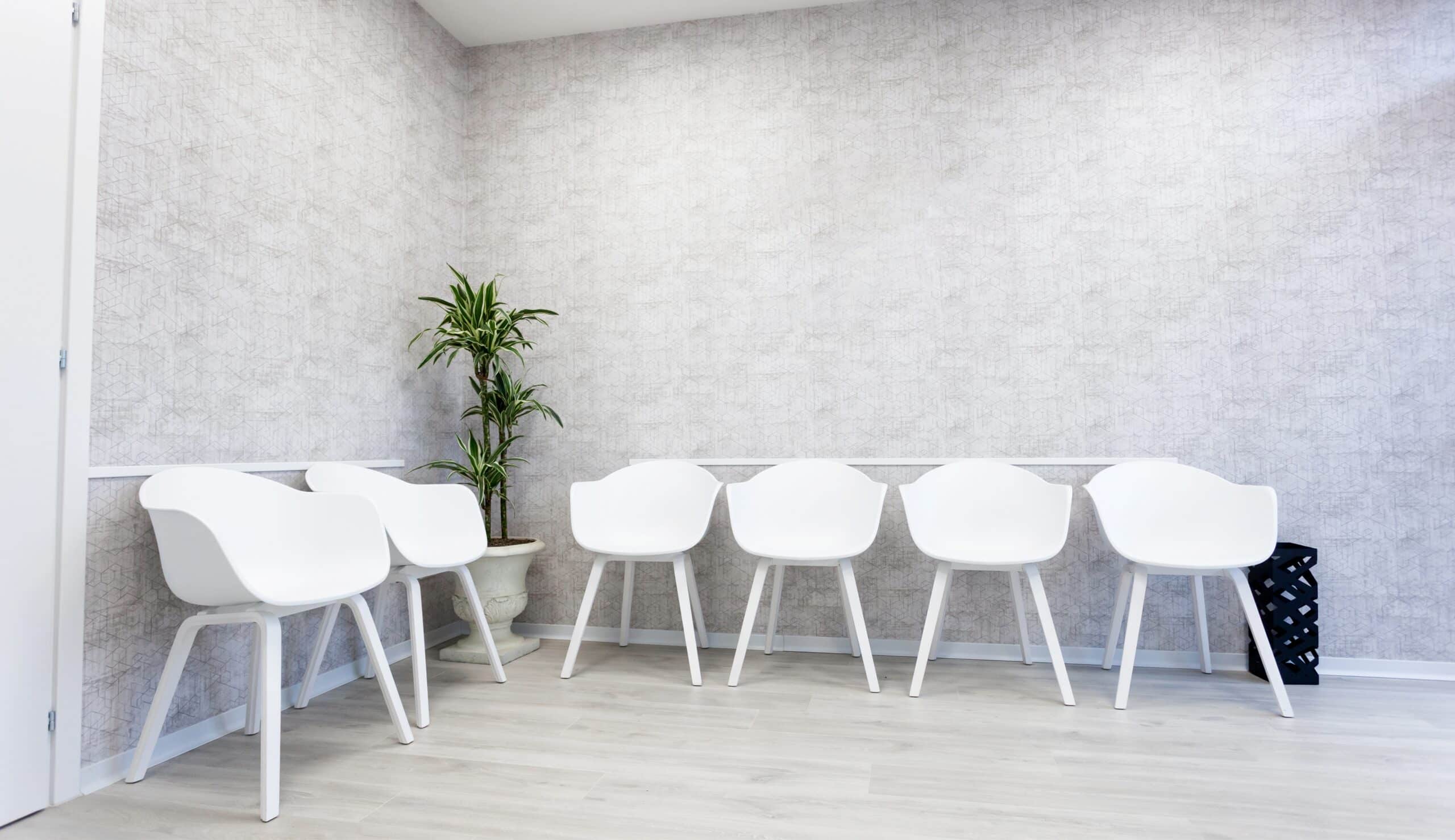 waiting,room,interior,with,six,white,chairs,on,the,parquet